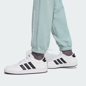 ADIDAS SPORTSWEAR - Tapered Calças de desporto 'Slogan' em verde