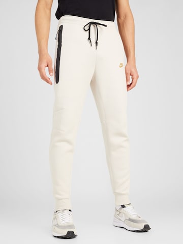 Tapered Pantaloni 'TCH FLEECE' de la Nike Sportswear pe bej: față