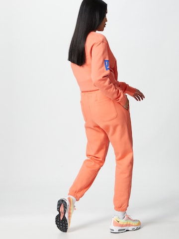 ABOUT YOU x Mero Loose fit Trousers 'Code' in Orange