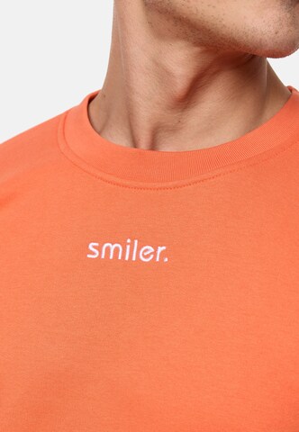 Sweat-shirt smiler. en orange