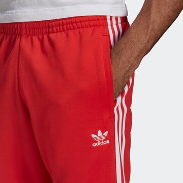 ADIDAS ORIGINALS - Tapered Calças 'Adicolor Classics Primeblue Sst' em vermelho