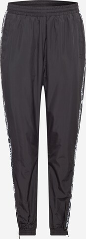 Karl Kani Tapered Trousers in Black: front