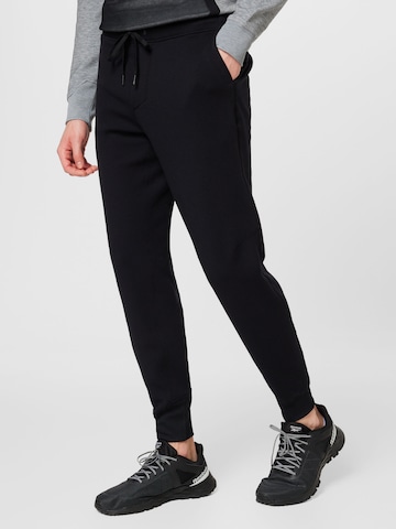 On Tapered Trousers in Black: front