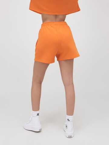 ABOUT YOU x VIAM Studio Regular Trousers 'BILLIE' in Orange: back