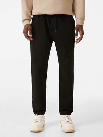 Bershka Tapered Jeans in Black: front