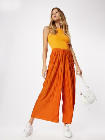ABOUT YOU Szeroka nogawka Spodnie 'Caren' w kolorze pomarańczowy