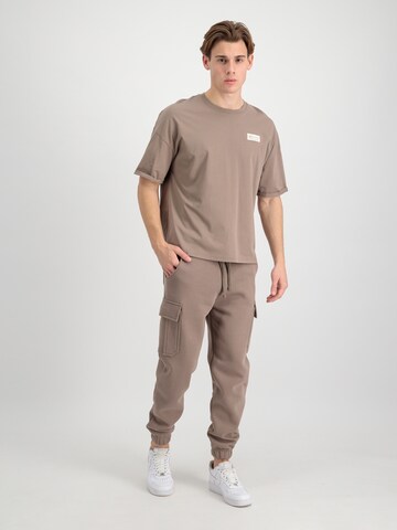 ALPHA INDUSTRIES Tapered Gargohousut 'Organics' värissä ruskea