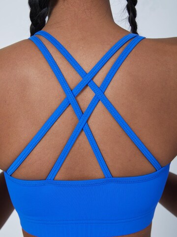 SPORTKIND Medium support Sport bh 'Crossed Straps' in Blauw