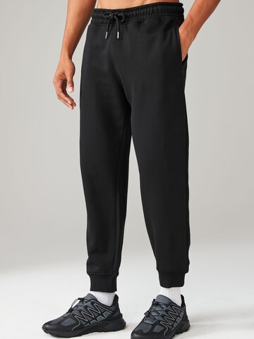 Next Tapered Trousers in Black: front