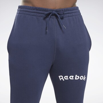 Reebok - Tapered Pantalón deportivo en azul