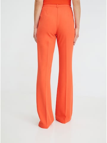 ABOUT YOU x Iconic by Tatiana Kucharova Flared Pants 'Jillian' in Orange