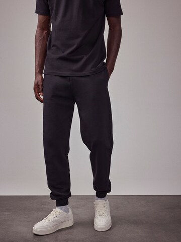 DAN FOX APPAREL Tapered Trousers 'The Essential' in Black: front