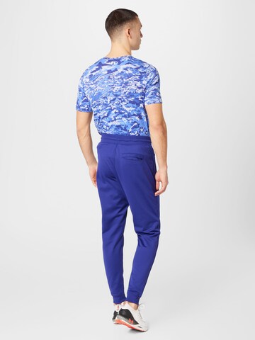 Effilé Pantalon de sport UNDER ARMOUR en bleu