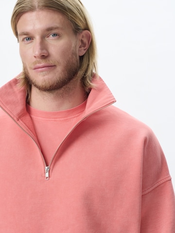 KARIA by Loris Karius Μπλούζα φούτερ σε πορτοκαλί