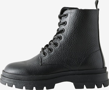 Next Saappaat värissä musta: etupuoli