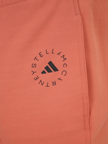 ADIDAS BY STELLA MCCARTNEY - Flared Calças de desporto 'Truecasuals ' em laranja