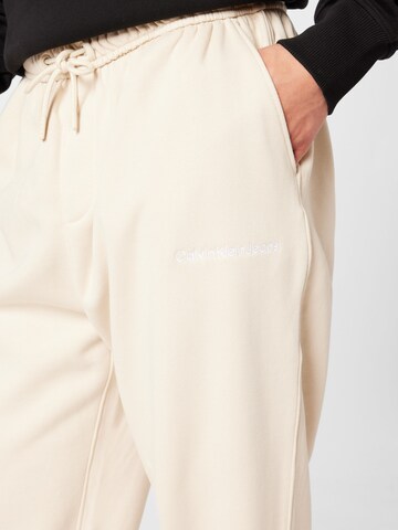 Calvin Klein Jeans Tapered Housut 'INSTITUTIONAL' värissä beige