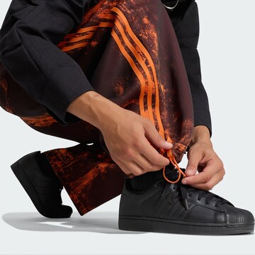ADIDAS ORIGINALSWide Leg/ Široke nogavice Hlače 'Adilenium 6' - narančasta boja