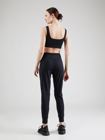 UNDER ARMOUR Tapered Sports trousers 'Motion' in Black