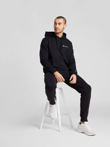 Champion Authentic Athletic Apparel Tapered Housut 'Legacy' värissä musta