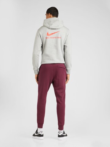 Tapered Pantaloni 'Club Fleece' de la Nike Sportswear pe roșu