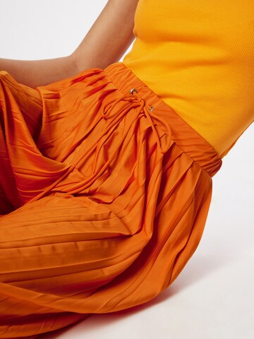ABOUT YOU Szeroka nogawka Spodnie 'Caren' w kolorze pomarańczowy