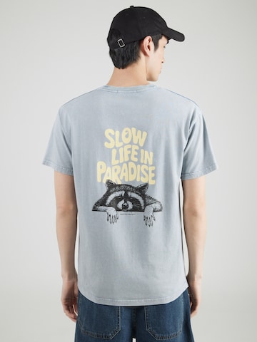 Maglietta 'SLOW LIFE IN PARADISE' di Kaotiko in grigio: frontale