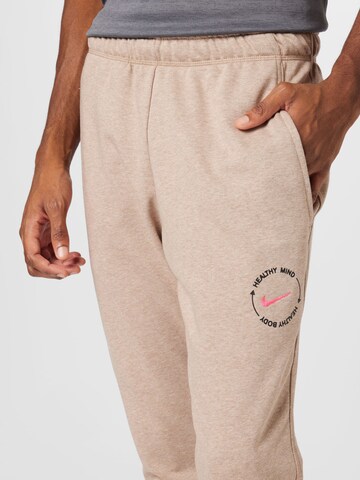 Effilé Pantalon de sport NIKE en beige