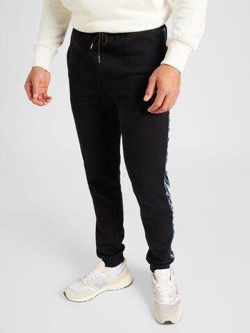 ELLESSE Tapered Trousers in Black: front