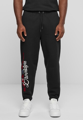 Karl Kani Tapered Pants in Black: front