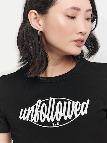 UNFOLLOWED x ABOUT YOU T-shirt 'GIRLFRIEND' i svart