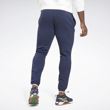 Reebok - Tapered Pantalón deportivo en azul