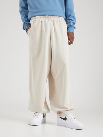 Effilé Pantalon 'CLUB' Nike Sportswear en beige : devant