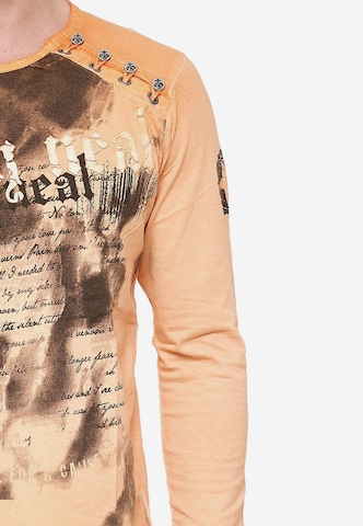 Rusty Neal Langarmshirt mit coolem Front- Print in Orange