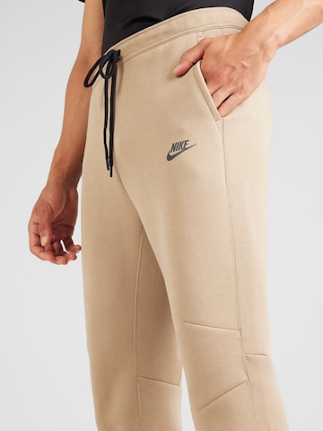 Nike Sportswear Zúžený Kalhoty 'Tech Fleece' – béžová