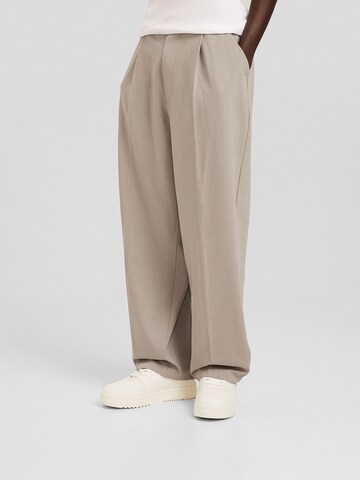 Bershka Loose fit Pleat-front trousers in Grey: front