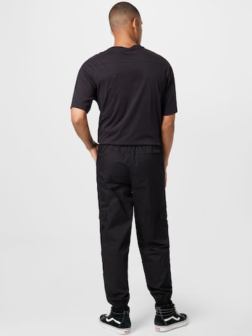 Tapered Pantaloni cu buzunare de la PUMA pe negru