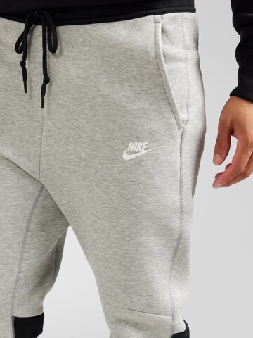 Nike Sportswear Tapered Housut 'TECH FLEECE' värissä harmaa