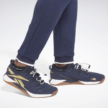 Reebok - Tapered Pantalón deportivo en azul