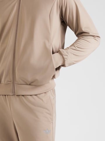 ADIDAS ORIGINALS Φόρμα τρεξίματος 'Tech Ess' σε καφέ
