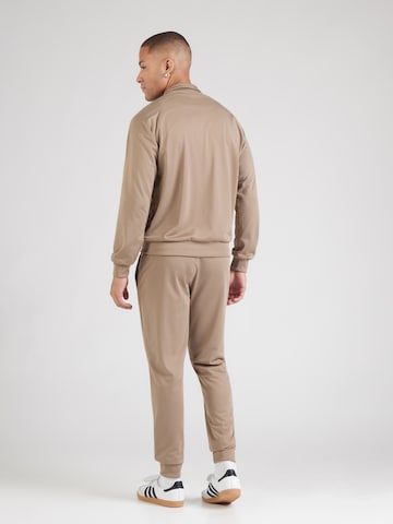 ADIDAS ORIGINALS Φόρμα τρεξίματος 'Tech Ess' σε καφέ