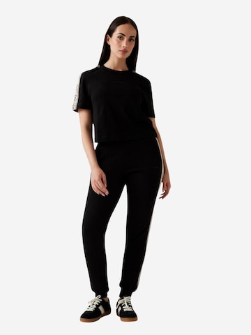 Top 'BRITNEY CROP TEE V3RI08 I3Z14' di GUESS in nero