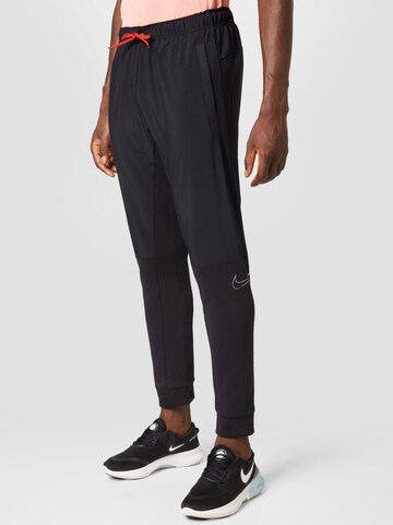 NIKE Tapered Workout Pants in Black: front