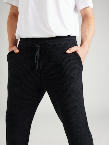 ABOUT YOU x Jaime Lorente Tapered Trousers 'Taylan' in Black