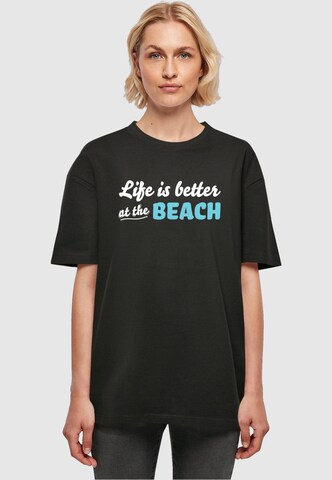 Merchcode T-Shirt 'Summer - Life Is Better At The Beach' in Schwarz: Vorderseite