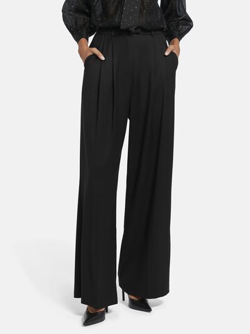 Nicowa Slimfit Anzughose 'ROSCIWO', weites Bein, Bundfalten, Model trägt Größe 34 in Schwarz