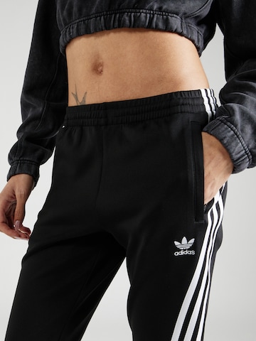 Flared Pantaloni di ADIDAS ORIGINALS in nero