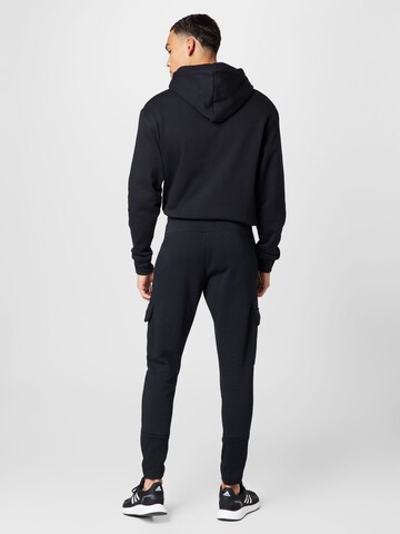 ADIDAS SPORTSWEAR - Tapered Calças de desporto 'Future Icons Fleece ' em preto