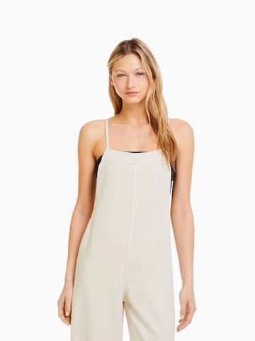 Bershka Loose fit Dungaree jeans in Beige: front