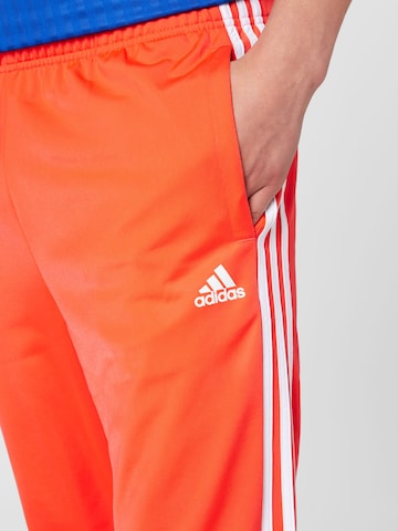 ADIDAS SPORTSWEAR Tapered Sportbyxa 'Essentials Warm-Up Tapered 3-Stripes' i röd